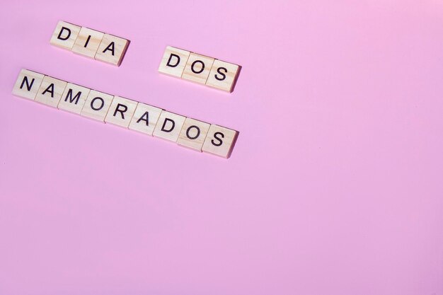 Top view dia dos namoradosValentine's Day lettering of alphabet wooden blocks on pink background