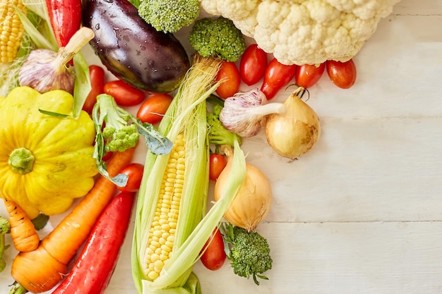 Top view of different fresh farm vegetables on the white background