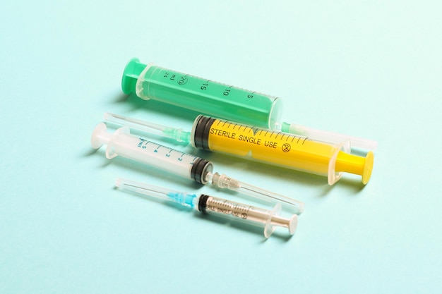 Top view of different syringes at blue background Medical injection concept with copy space