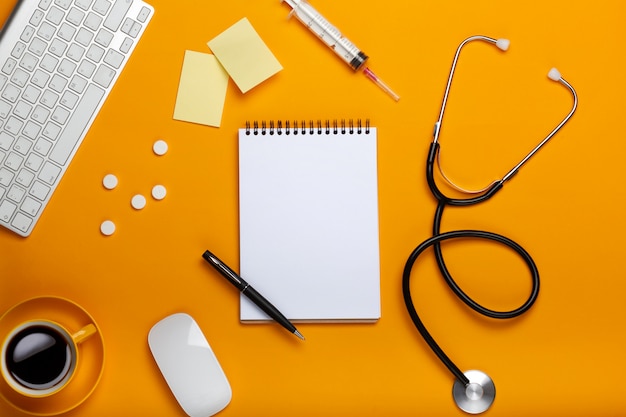 Top view of a doctor's table with notepad and pen stethoscope