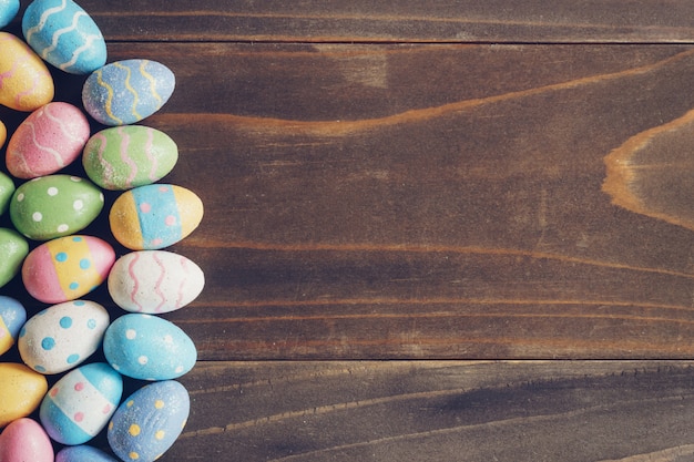 Top view of Easter eggs on rustic wood background with copy space