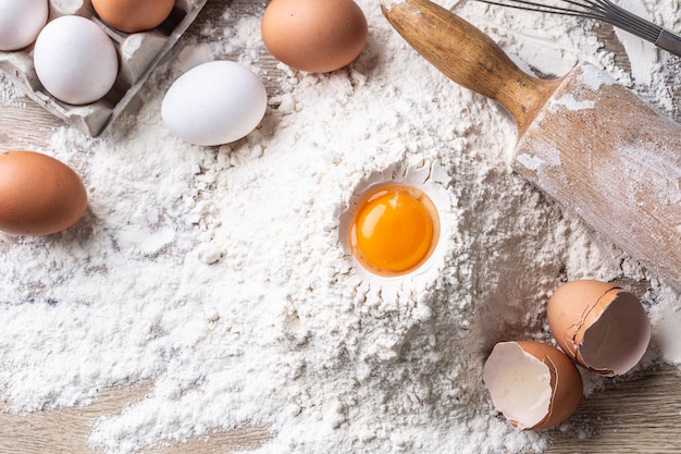 Top view of egg yolk flour and roller on kitchen table