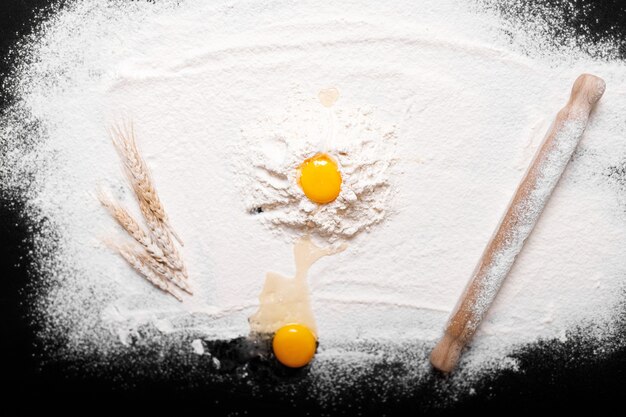 Top view eggs, dough, flour  on black table background