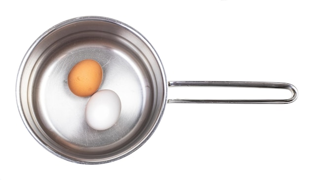 Photo top view of eggs in saucepan with water isolated