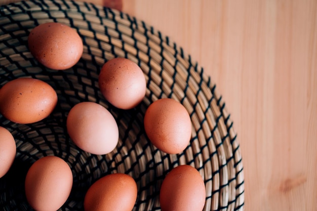 Top view eggs on the table round wicker Board in the kitchen