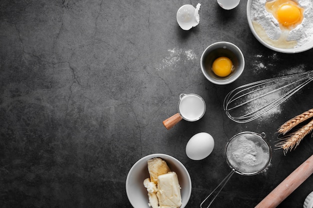 Top view eggs with butter and flour on the table