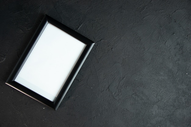 Top view of empty picture frame on dark wall