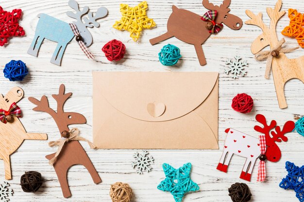 Photo top view of envelope on festive wooden background christmas toys and decorations new year time concept