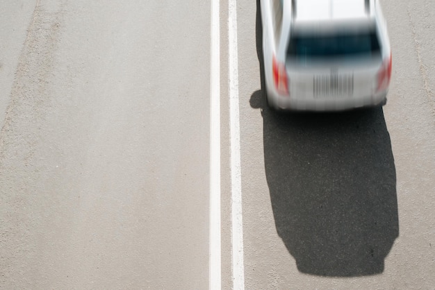 Top view of fast moving car on road Blurred motion selective focus on dividing double solid marking line on asphalt