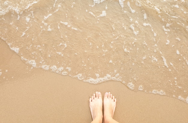 Top view of feet on beach.