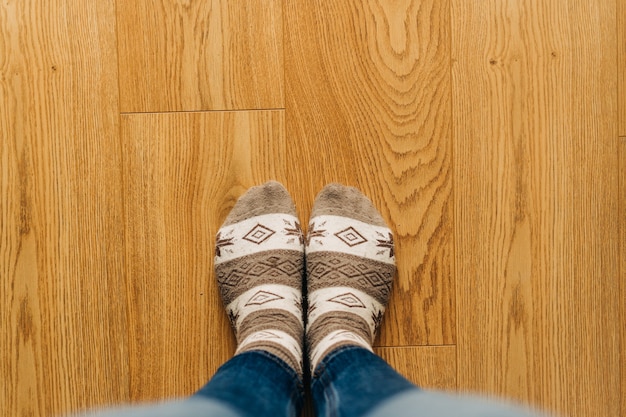 Top view of feet in warm socks on the wooden floor