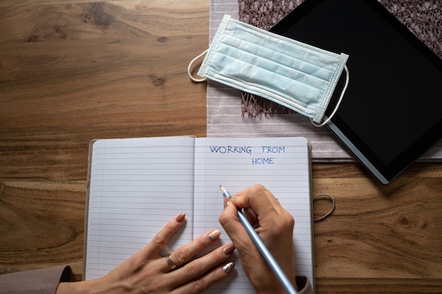 Top view of female hands writing in notebook