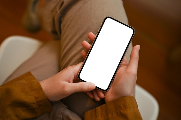 Top view Female scrolling on her social media via smartphone phone white screen mockup