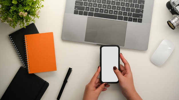 Top view A female using smartphone on her modern office desk