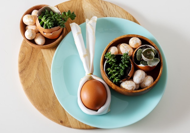 Top view flat lay egg with bunny ears on blue plate serving for easter celebration