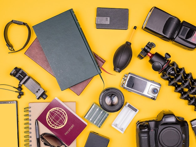 Top view flat lay of traveler blogger kit on yellow background. Summer vacation concept