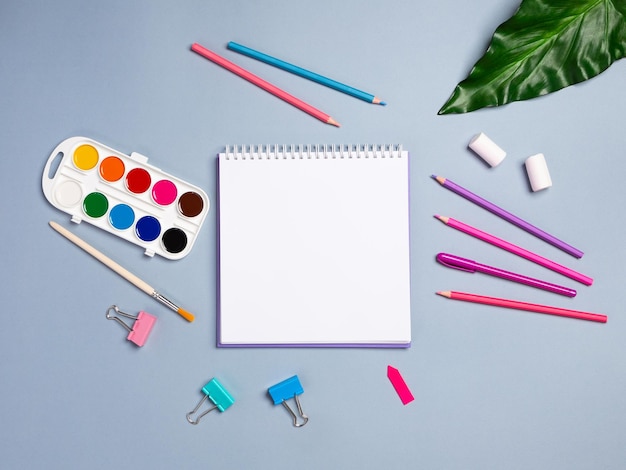 Top view of a flat work desk lies a notebook with blank sheets and stationery Template for women's blogs in social networks