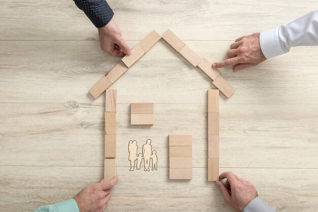 Top view of four people making the shape of a residential house