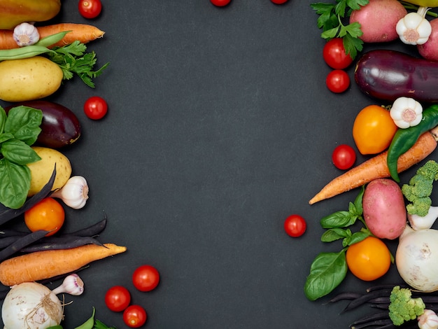 Top view of frame of various vegetables on dark background