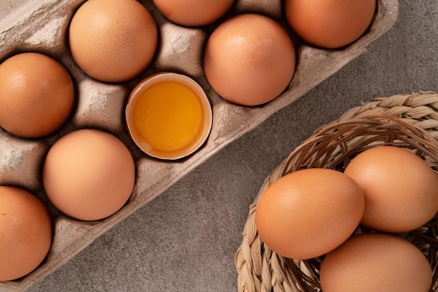 Top view of fresh brown chicken eggs in a plate on gray table background