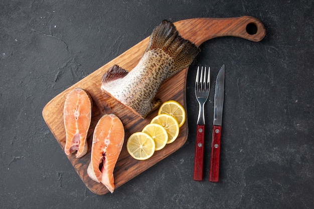 top view fresh fish with lemon slices on dark background salad ocean seafood meal food meal sea fish meat water