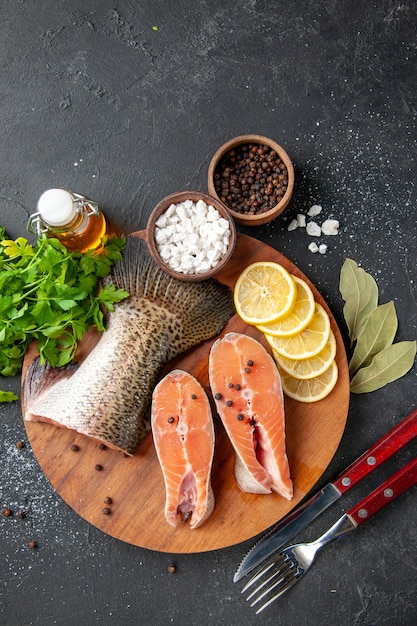 top view fresh fish with lemon slices and seasonings on the dark background seafood meal food meal water fish meat ocean salad sea