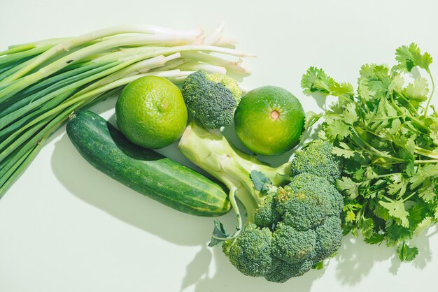 Top view of fresh green vegetables on green background