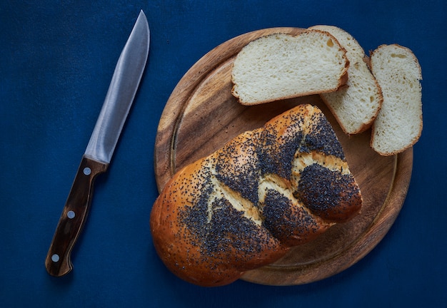 Top view of a fresh white bread loaf sprinkled with poppy