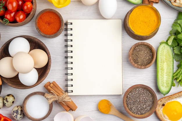 Top view fresh white eggs with vegetables and seasonings on a white background meal color ripe lunch food salad breakfast