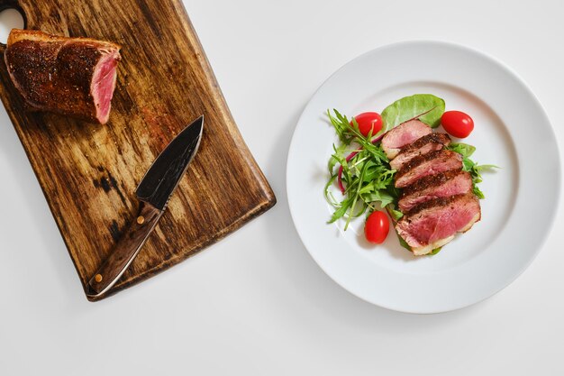 Top view of fried duck breast medium rare served on a plate