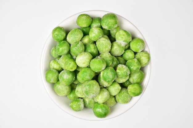 Top view of frozen peas in bowl isolated on white background with clipping path