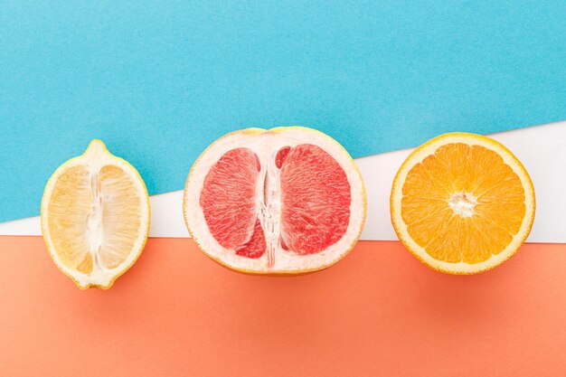 Top view of fruits halves on blue orange and white background