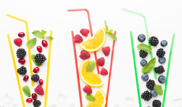 Top view of fruits in straw glasses with mint