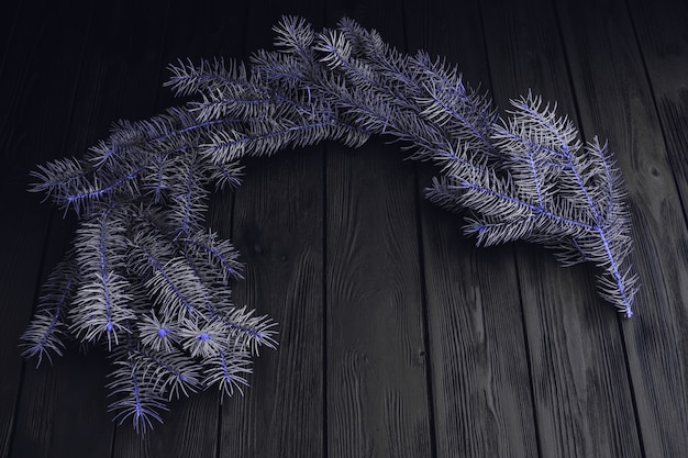 Top view of fur-tree branches and balls frame on wooden background