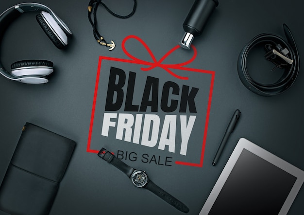 Top view of gadgets with black friday lettering on black background. Copyspace for your ad. Black friday, sales, finance, advertising, money, finance, purchases concept. Headphone, watch, tablet.