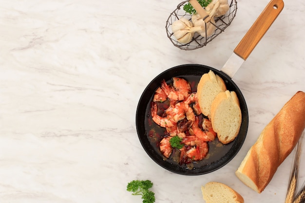 Top View Gambas al aJillo. Shrimp Scampi on a Skillet. Traditional Spanish Tapa with Prawns Cooked in Olive  Oil with Garlic and Chilli. Served with Baguette, Copy Space for Text