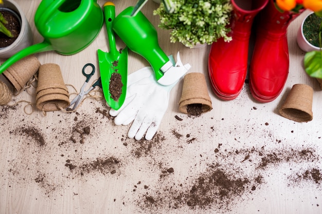 Photo top view of gardening tools and potted plants on wooden table background