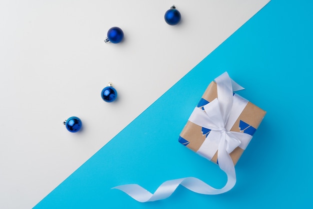 Top view of gift box with ribbon on blue background with copy space