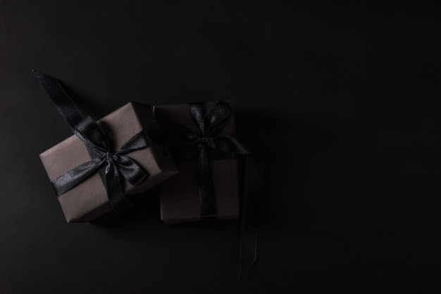 Top view of gift box wrapped in black paper and black ribbon