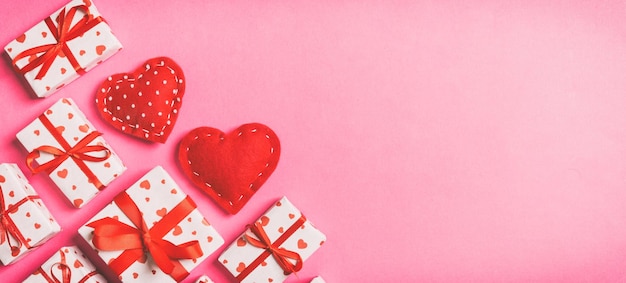 Top view of gift boxes and red textile hearts on colorful background St Valentine's day concept with copy space