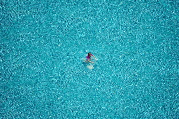 Top view of girl swimming in the pool