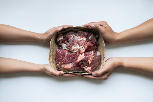 The top view of giving of sacrificial meat on Eid alAdha isolated by white background