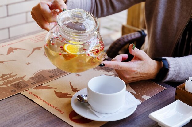 Top view of glass teapot and cups of tea on a table at restaurant close up. Tea ceremony. Holiday