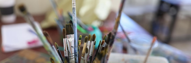 Top view of glasses with paint brushes at artist workplace teaching painting and drawing