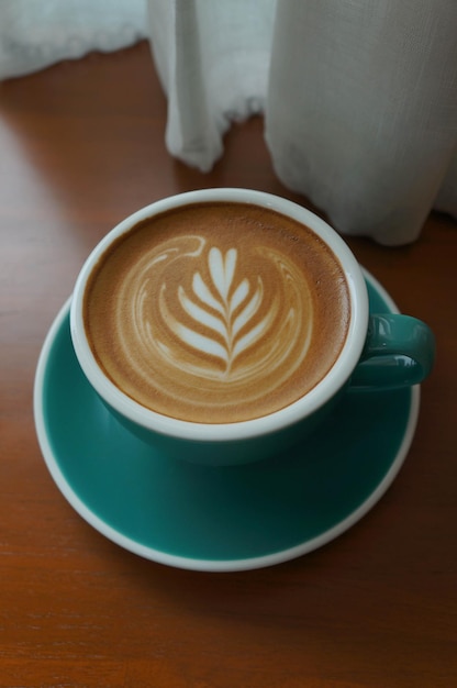 Top view of green cup of cappuccino on table