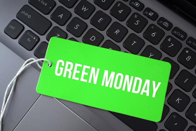 Top view of green paper card and the text green monday on a laptop background