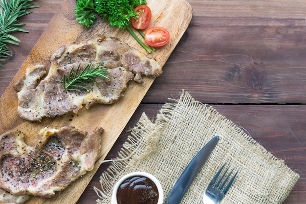 Top view grilled beef steak on wooden cutting board