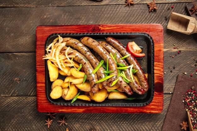 Top view on grilled sausages with potatoes