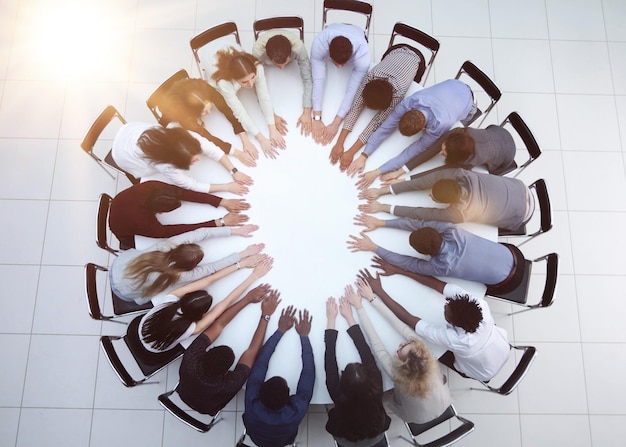 Top view of group of multiethnic busy people working in office aerial view of sitting at negotiating table business meeting concept