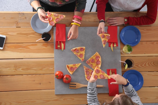 Top view of group of people having dinner together while sitting at wooden table Food on the table People eat fast food